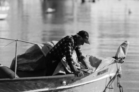 Fisherman working on a boat near the water