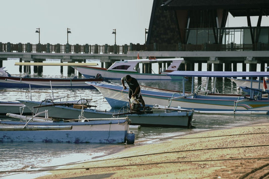 Boats docked at a pier with a person working